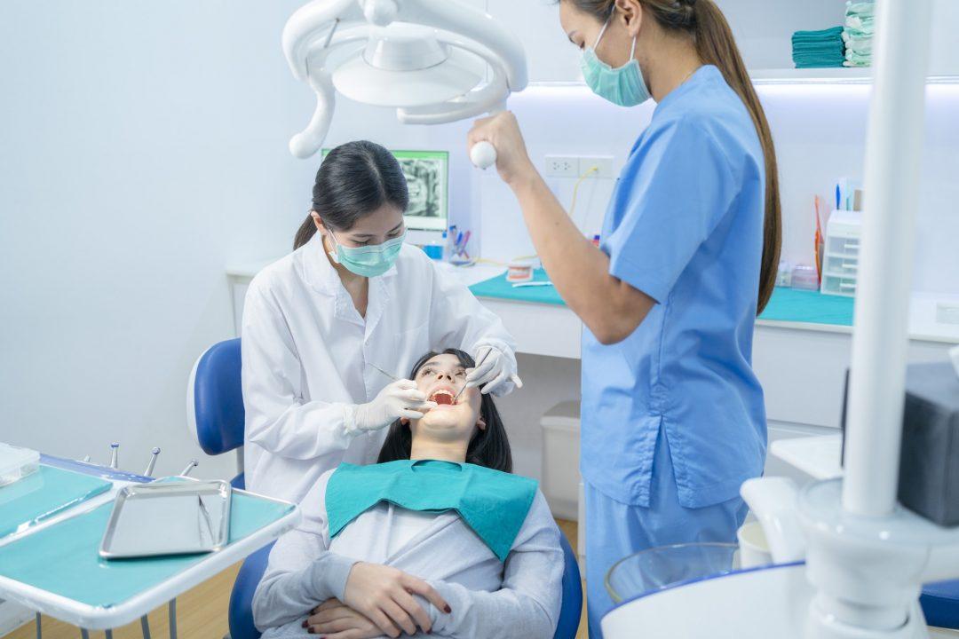 asian-dentist-adjust-dental-surgical-light-then-starts-examining-tooth-patient-at-dental-clinic.jpg